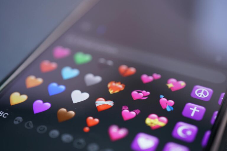 Smartphone affichant un emoji cœur rouge sur fond sombre, symbole d'amour numérique