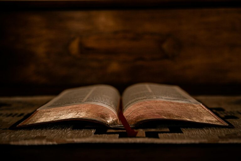 Vieille Bible ouverte sur un texte sacré, lumière dorée tamisée