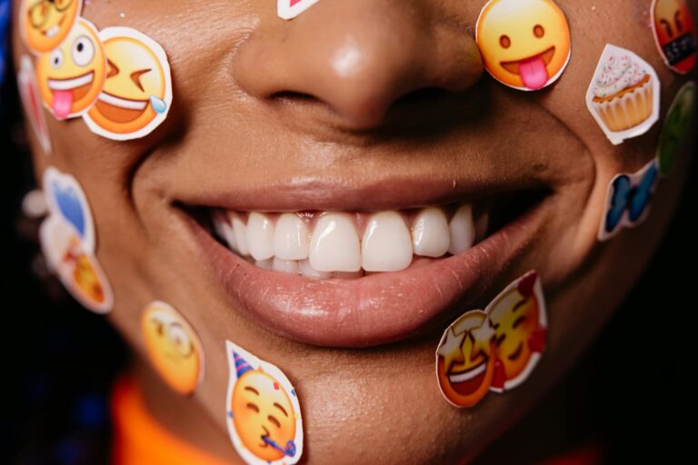 Visage souriant avec joues roses sur fond coloré, émoji numérique expressif
