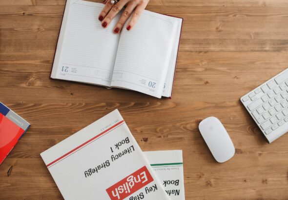 Tableau de conjugaison anglaise ouvert sur un bureau avec stylo et cahier de notes