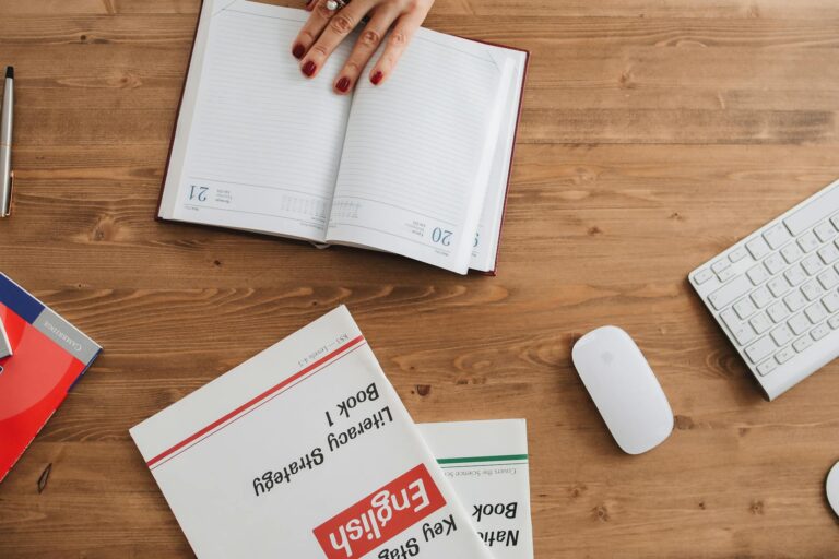 Tableau de conjugaison anglaise ouvert sur un bureau avec stylo et cahier de notes