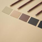 palette de nuances ébène émeraude écarlate écru posée sur table lumineuse