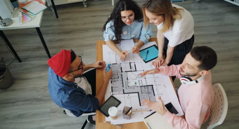 Promoteurs immobiliers travaillant sur plans de construction au bureau